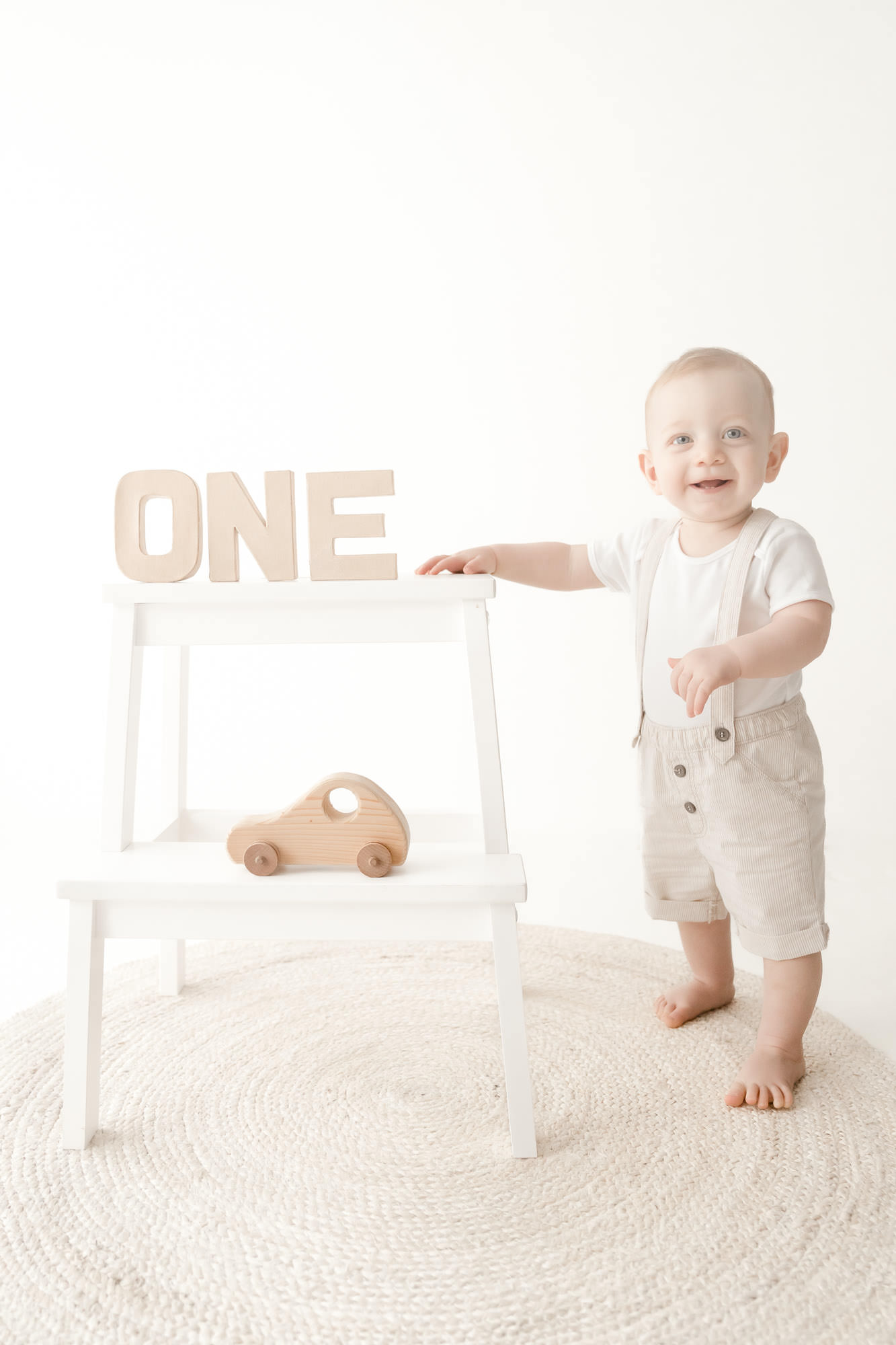 Baby standing for first birthday cake smash portrait photography at Colchester studio