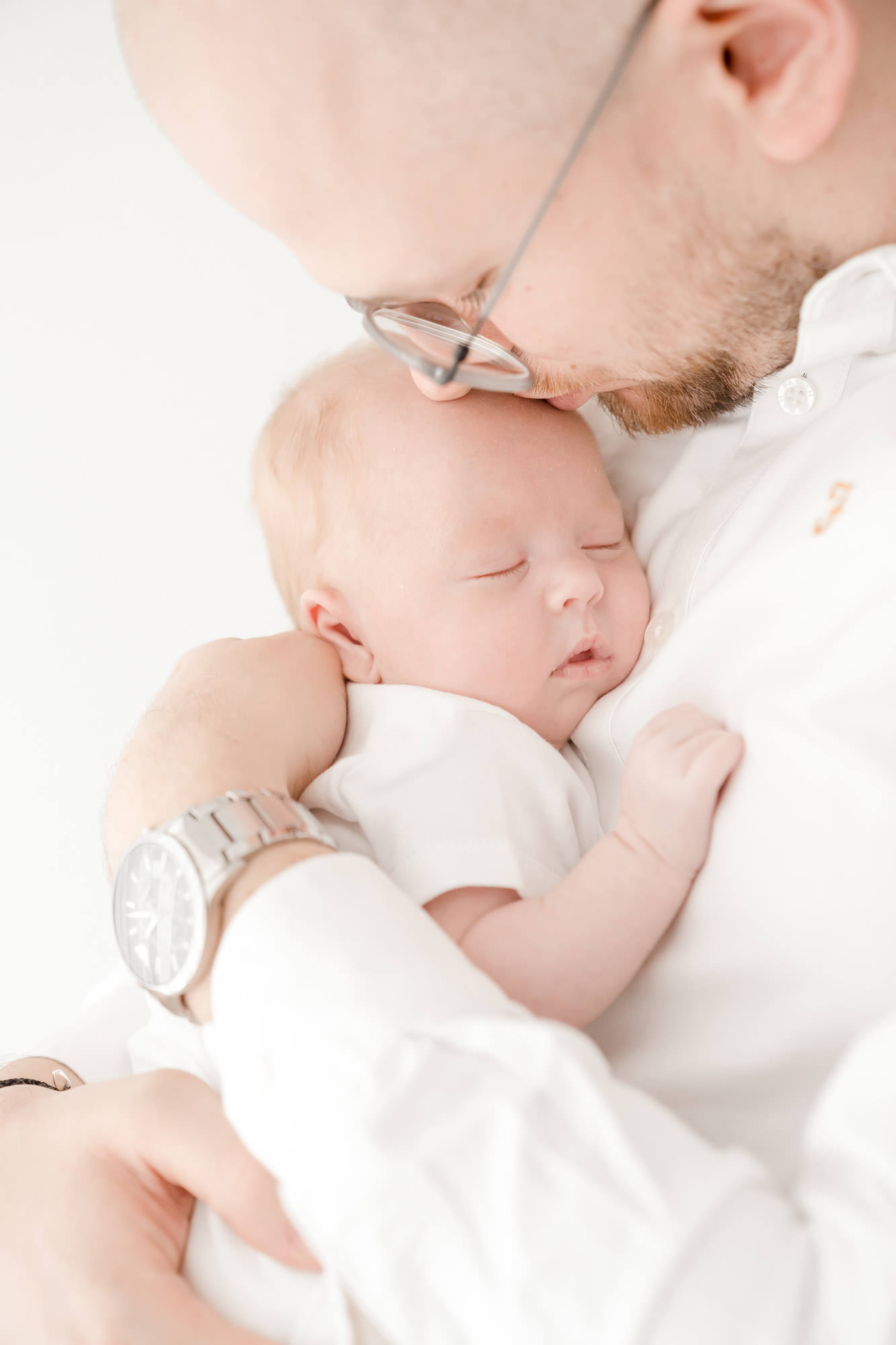 dad kissing newborn baby at photography experience in colchester