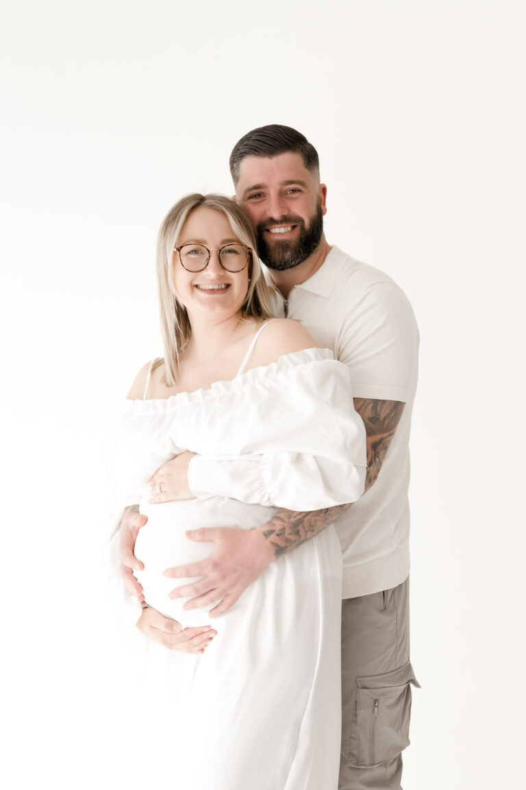 Mother and father to be cuddling at colchester maternity photoshoot