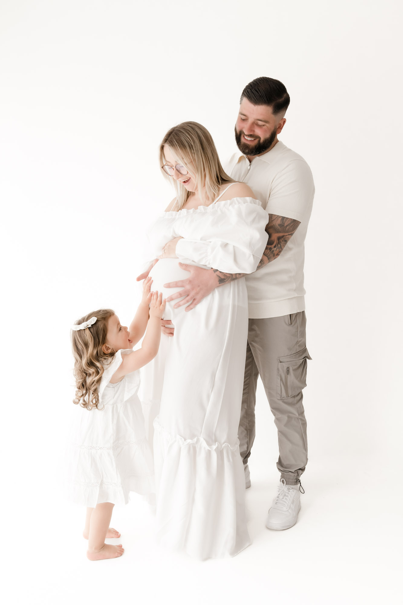 Family touching pregnant mother's belly at colchester maternity photoshoot